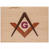Wooden plaque with inlaid square, compass, and G symbol for woodworking decor.