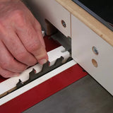 Hand using dado blade setup jig on table saw for woodworking precision