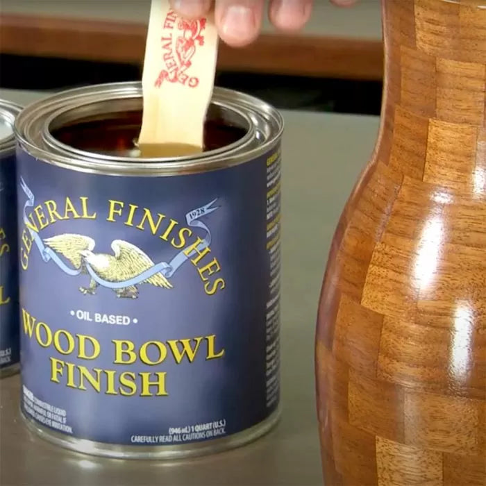 Oil based wood bowl finish can with stir stick beside polished wooden vase