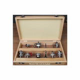 Open wooden router bit storage box with foam lid insert, displayed on a workbench