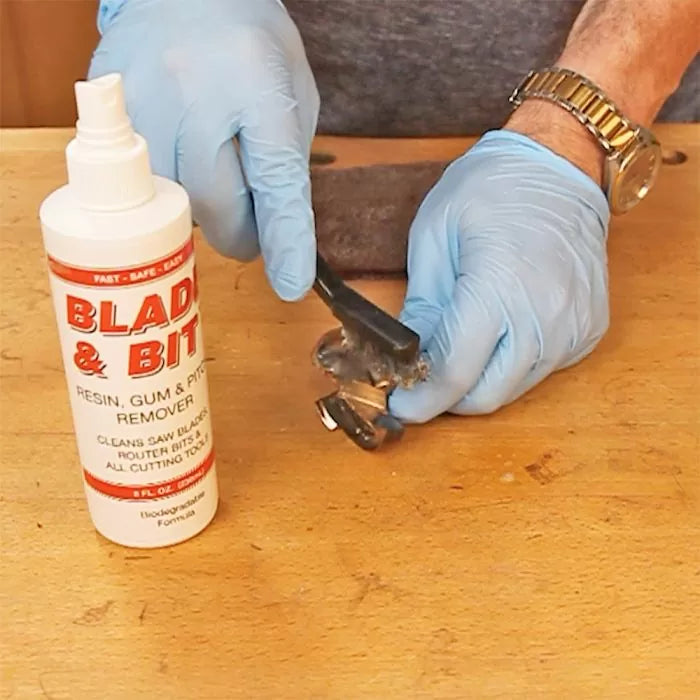 Person cleaning router bit with Blade & Bit resin remover on a woodworking bench