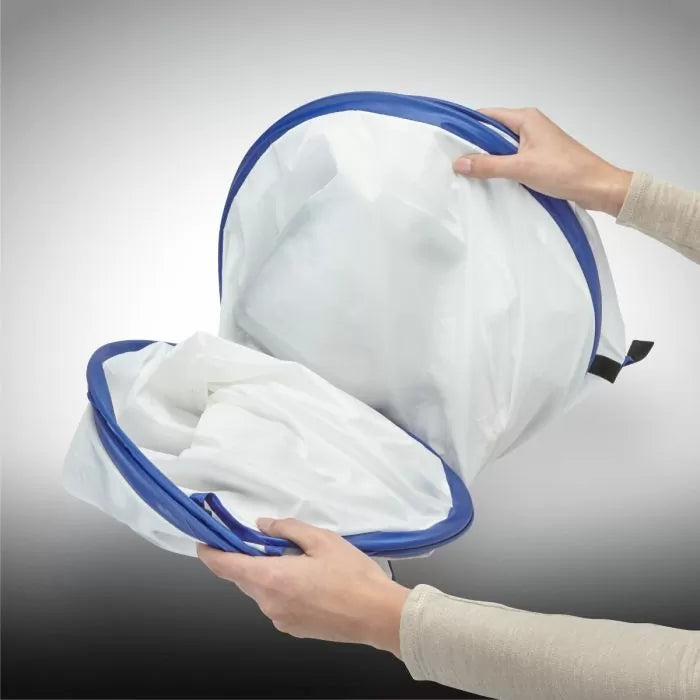 Hands holding collapsible small spray shelter with blue trim for woodworking and painting projects