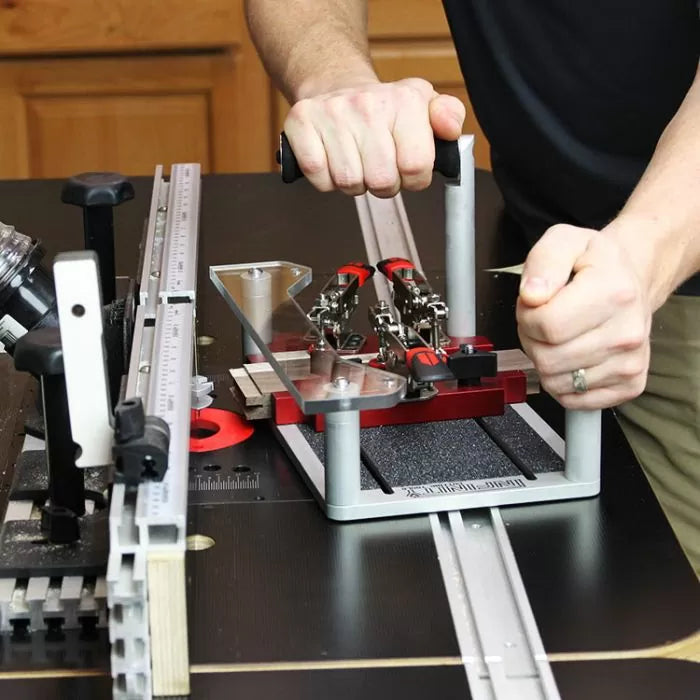 Woodworker using a precision router table sled with clamps and guide rails for woodworking