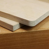 Close-up of wood boards with rounded and square edges, showcasing precise woodworking cuts