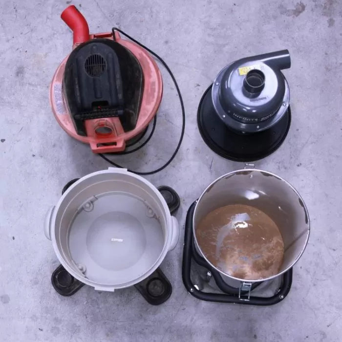 Shop vacuum and dust separator lids with empty dust collection bins on a concrete floor