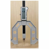 Digital height gauge marking tool on wood panel for precision woodworking measurements