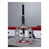 Digital height gauge measuring router bit height on a router table in a woodworking shop