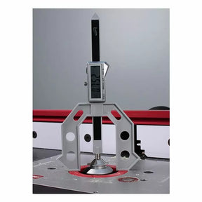 Digital height gauge measuring router bit height on a router table in a woodworking shop