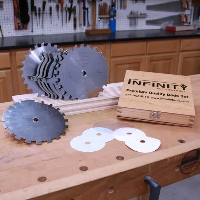 Premium dado blade set with metal saw blades, shims, and wooden case on workbench in woodworking shop