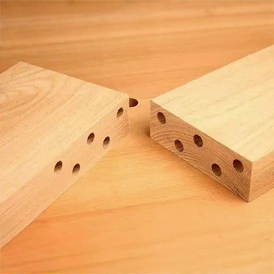 Precision-drilled dowel holes in two hardwood boards for woodworking joinery