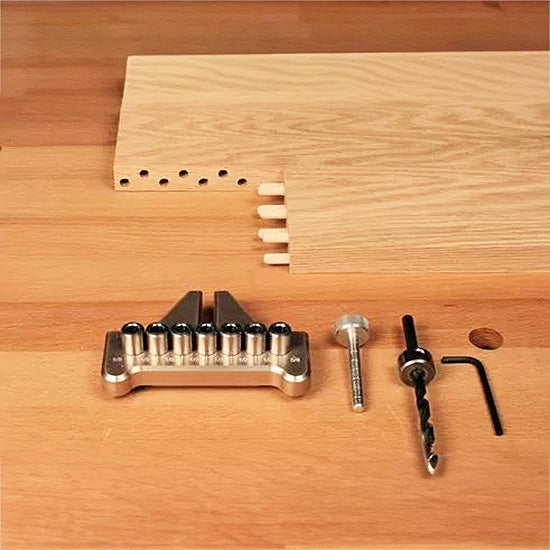 Woodworking dowel jig kit with drill bit, hex key, and wooden boards on a workbench
