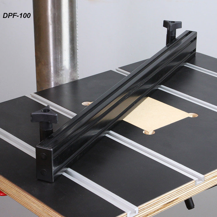 Drill press fence mounted on a woodworking table with T-slots for precision alignment.