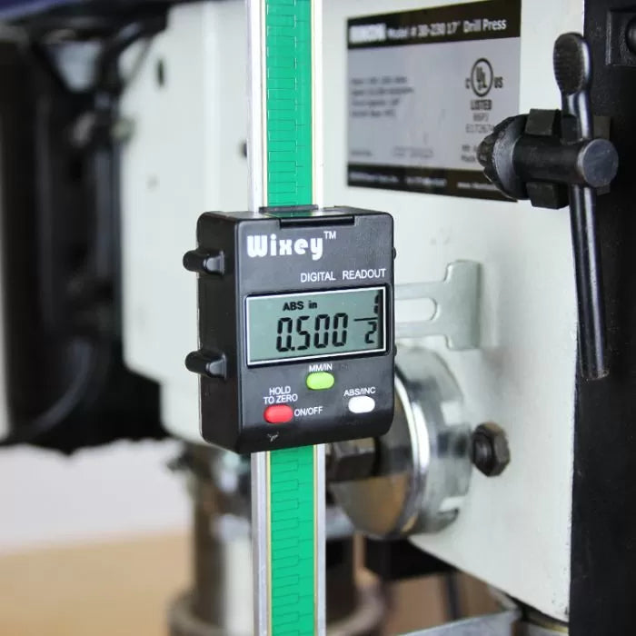 Digital readout depth gauge attached to a drill press for precise woodworking measurements.