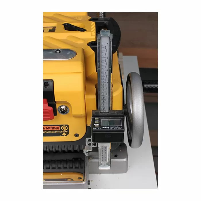 Digital height gauge attached to yellow woodworking planer for precise cutting adjustments