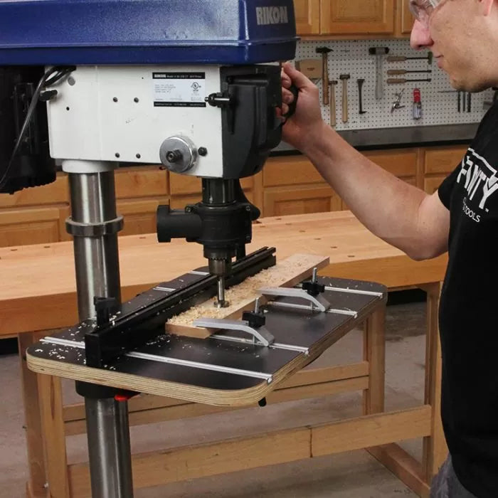 Woodworker using a drill press table jig for precise woodworking and drilling tasks