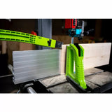 Bandsaw with green featherboard and fence cutting wood, woodworking safety accessory in use
