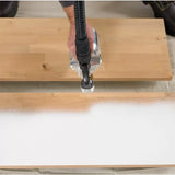 Hand using a paint sprayer to coat a wooden board for woodworking projects