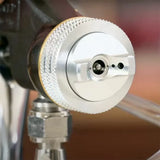 Close-up of a metal spray gun nozzle for woodworking finishing applications