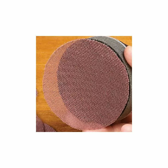 Close-up of round mesh sanding disc on hand block for woodworking