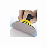 Hand using a yellow mesh sanding tool for woodworking surface finishing