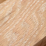 White grain filler applied to unfinished wood surface, highlighting wood grain texture.