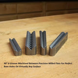 Set of precision milled V-groove woodworking jigs on a workbench for accurate bore holes