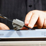 Sharpening a chisel with honing guide on sharpening stone, woodworking tool detail