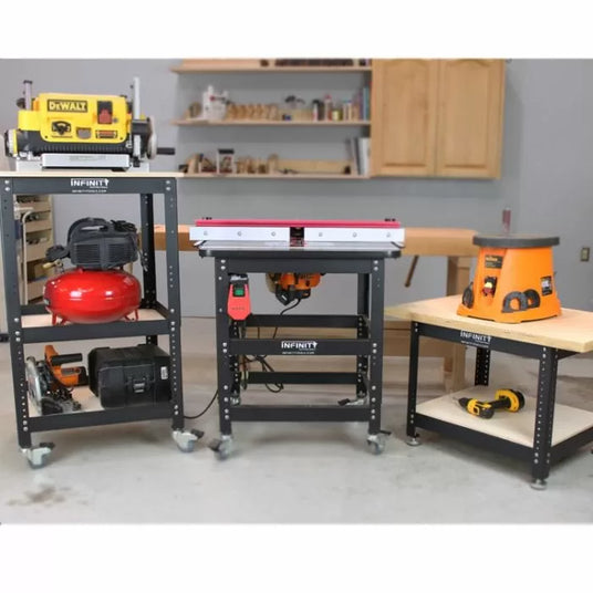 Workbench setup with planer, air compressor, router table, spindle sander, and power drill in a woodworking shop.