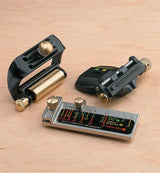 Woodworking honing guide set with brass and steel components on a light wood surface.