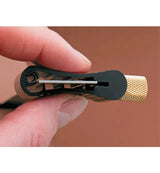 Close-up of a hand holding a woodworking marking gauge with a brass knurled adjustment knob