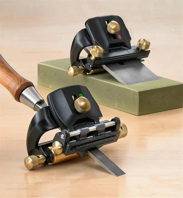 Woodworking honing guides with brass adjustment knobs sharpening blades on a sharpening stone