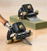 Woodworking honing guides with brass adjustment knobs sharpening blades on a sharpening stone