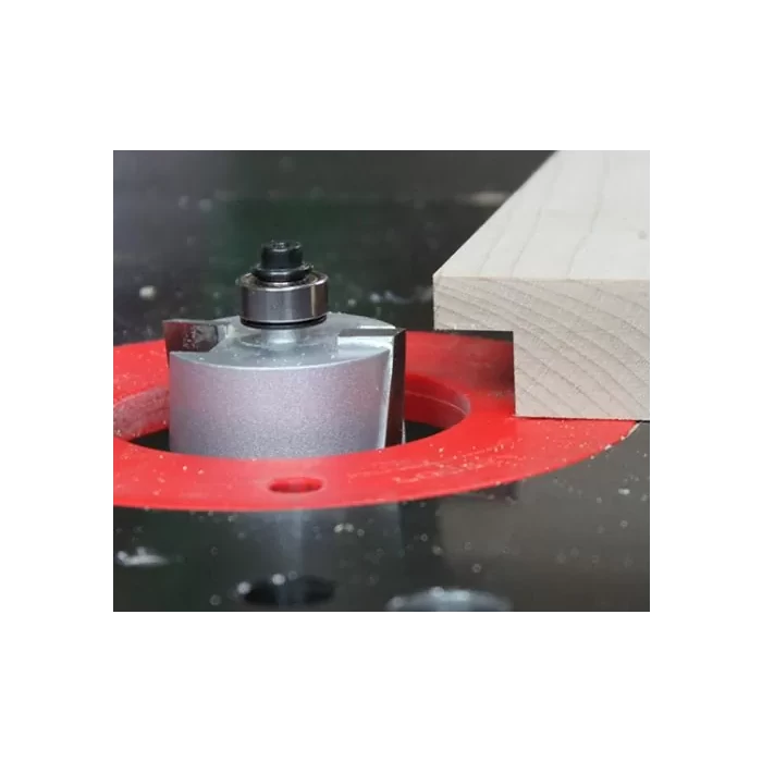 Router bit cutting a rabbet joint in wood on a router table