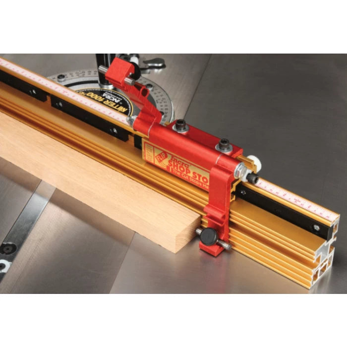 Miter gauge with flip stop and ruler on a table saw fence, holding a wood board