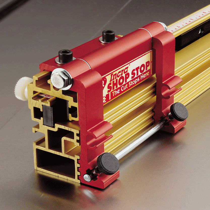 Precision aluminum router table stop block with red and gold accents on metal surface
