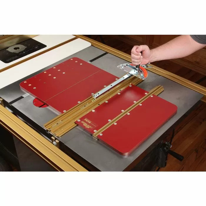 Woodworker using a crosscut sled on a table saw with red panels and miter gauge