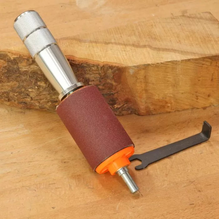 Drum sander attachment with wrench on wooden surface for woodworking tools