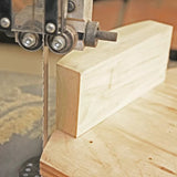 Bandsaw cutting wood with precision in a woodworking shop setting