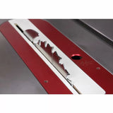 Close-up of a table saw blade installed in a red insert plate for woodworking.
