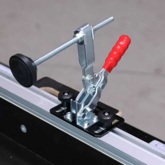 Toggle clamp with red handle mounted on woodworking jig for secure workpiece holding