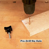 Drill creating pilot hole in wood on workbench, woodworking knob and bolt nearby