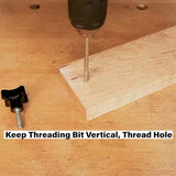 Drill with threading bit cutting screw threads in wood, knob and bolt on workbench