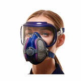 Woman wearing a full face woodworking respirator mask with clear shield and dual filters
