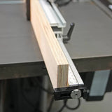 Plywood board aligned with a table saw fence and measuring guide for precise cutting