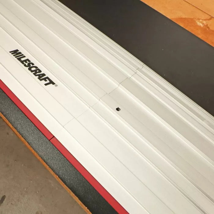 Aluminum woodworking track guide rail with Milescraft logo on a workbench