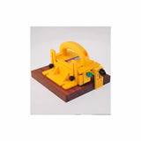 Yellow woodworking push block safety tool on a wooden board for table saws and router tables