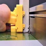 Woodworker using yellow push block and jointer to edge joint a board