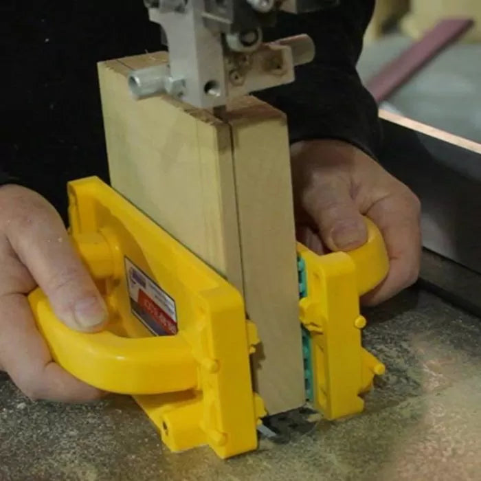 Person using push block for safe bandsaw woodcutting in woodworking shop