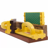 Yellow woodworking push block with green non-slip pad on wood boards, safety tool for table saws