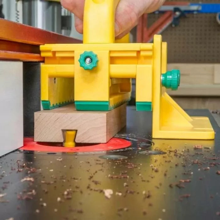 Router table push block guiding wood over router bit for precise woodworking cut